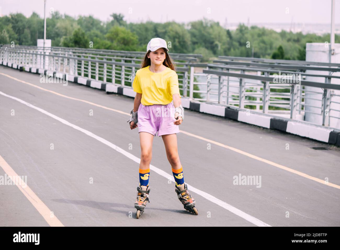 Preteen girl roller skating in the park, doing outdoor activities