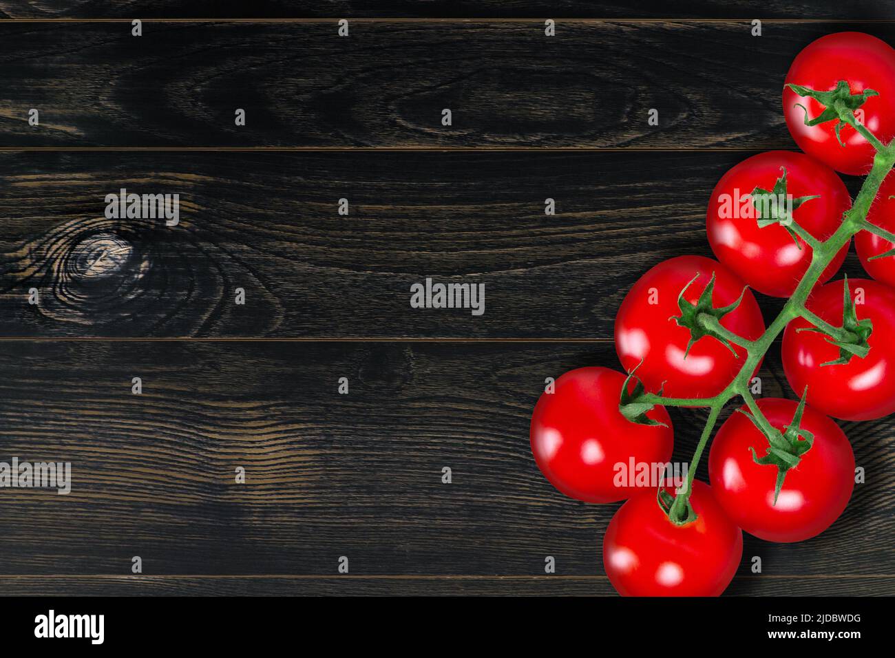 Tomato branch on dark vintage wooden plank background Stock Photo