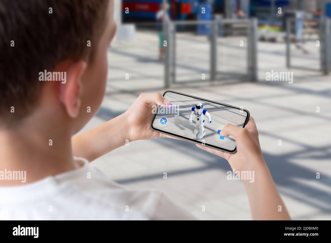 Boy programs and controls the robot on the street via augmented reality technology concept Stock Photo