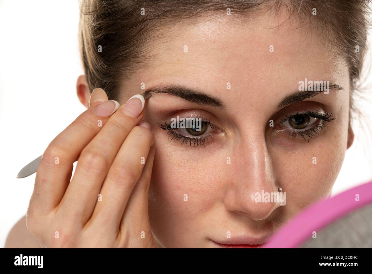 Young woman plucking eyebrows with tweezers close up Stock Photo Alamy