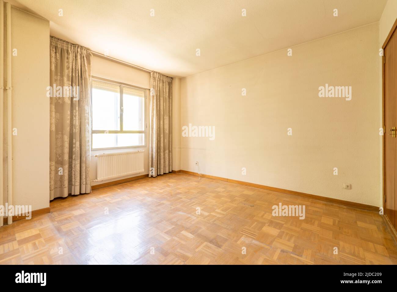 Empty room with light oak floorboards, iron and glass window, metal