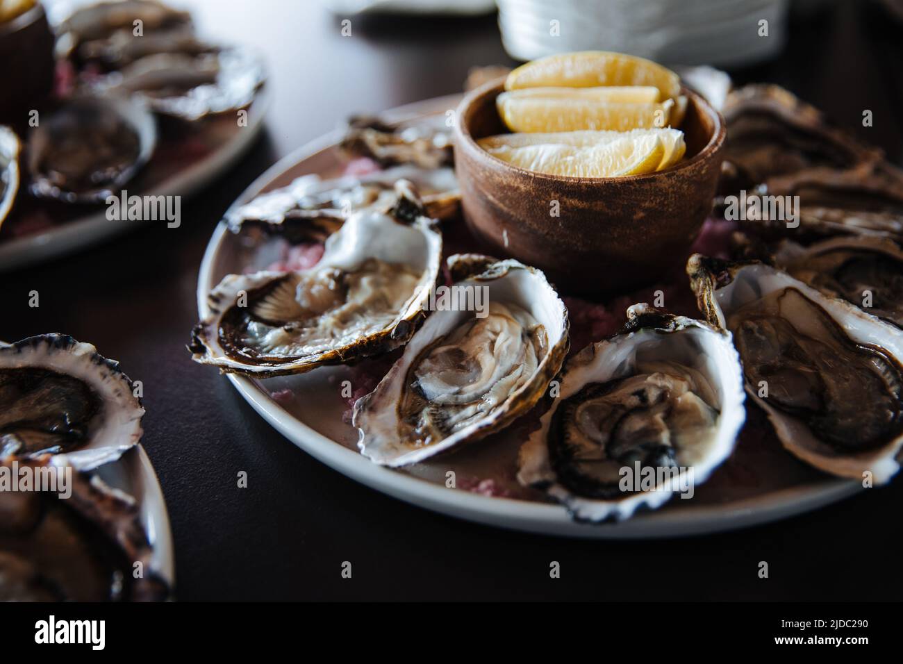 Fresh oysters on plate, served table with oysters, lemon in restaurant. Gourmet food. Stock Photo