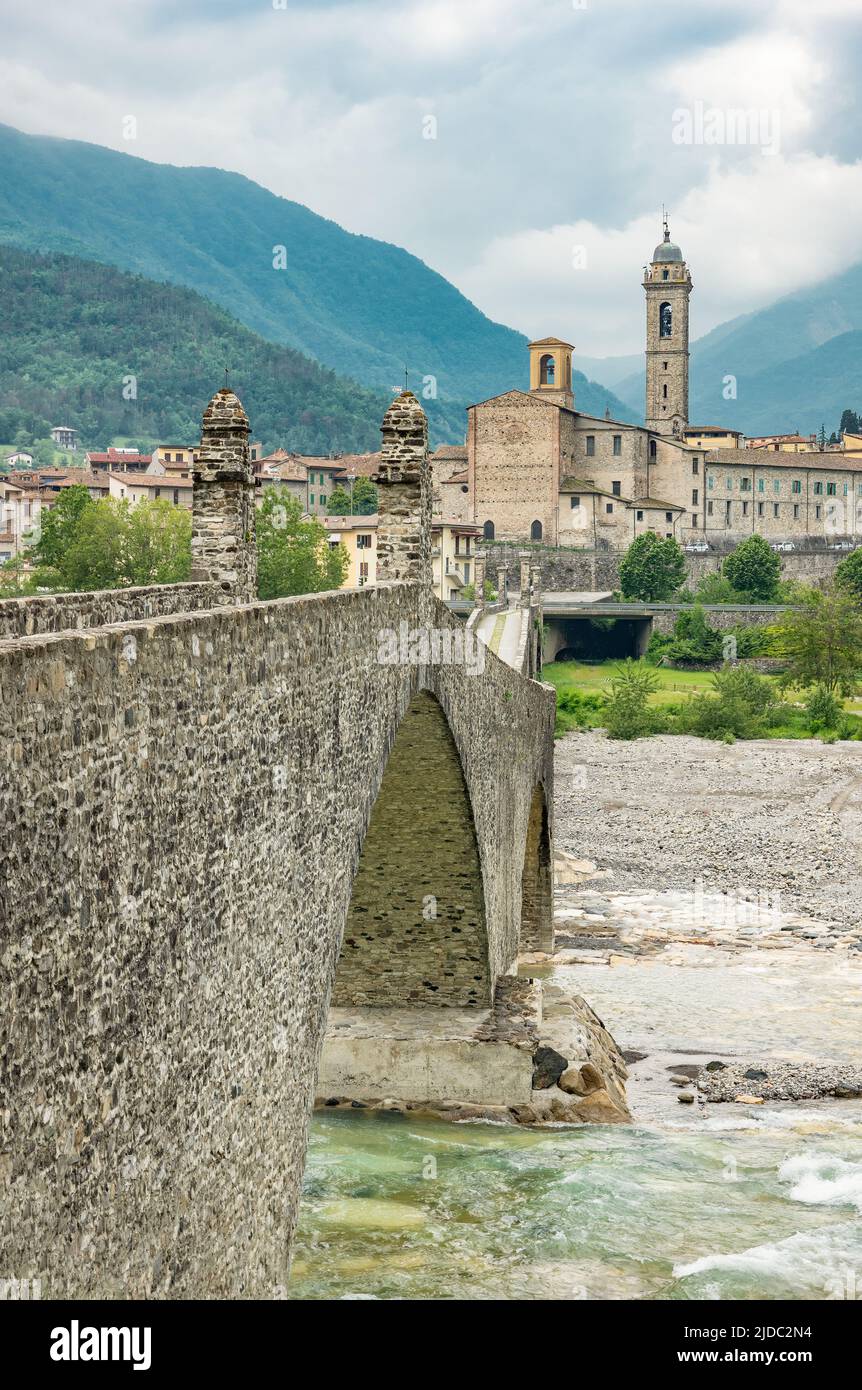 Bobbio, Italy , the Old Bridge (also known as the Devil's Bridge) over the Trebbia river, with the country in the background Stock Photo