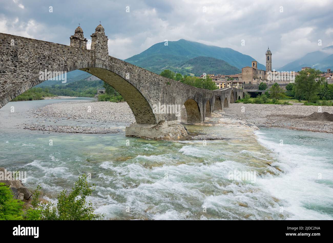 Bobbio, Italy , the Old Bridge (also known as the Devil's Bridge) over the Trebbia river, with the country in the background Stock Photo