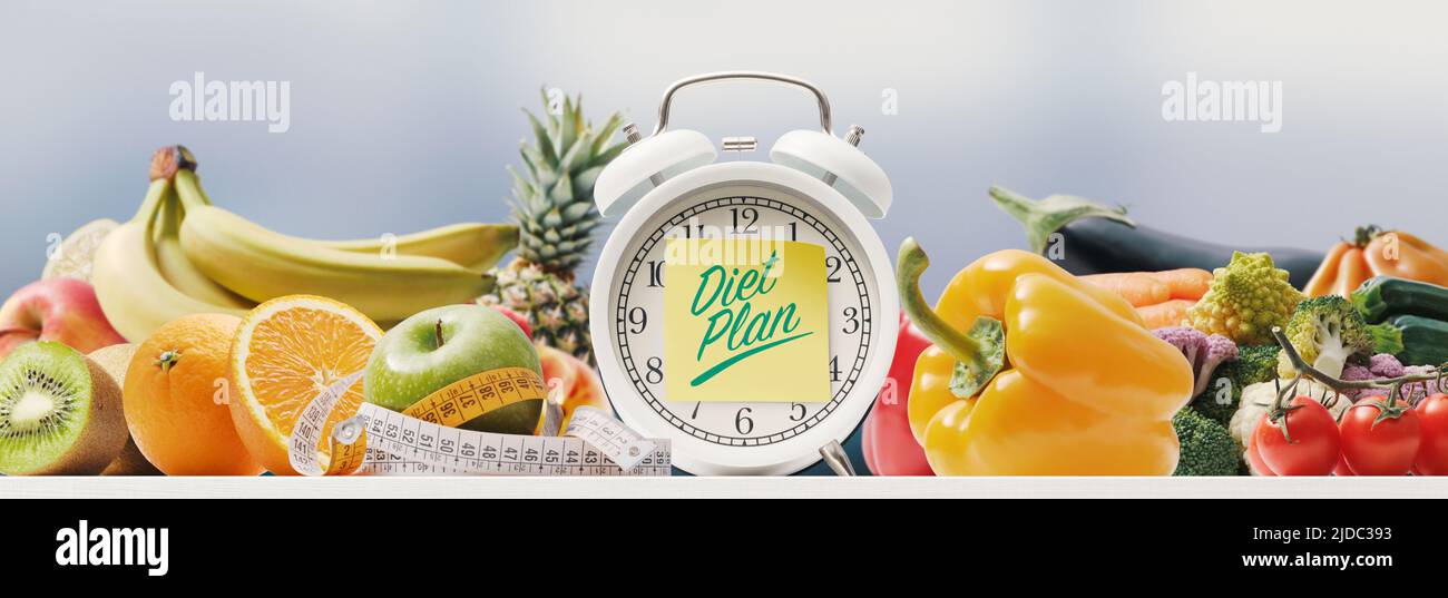 Diet plan and healthy eating alarm clock with sticky note and lots of
