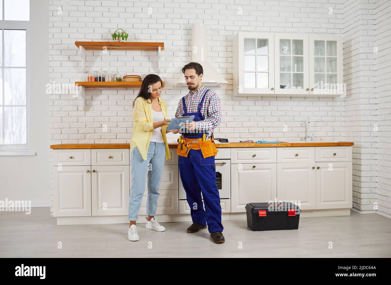 Female client sign deal with male plumber Stock Photo