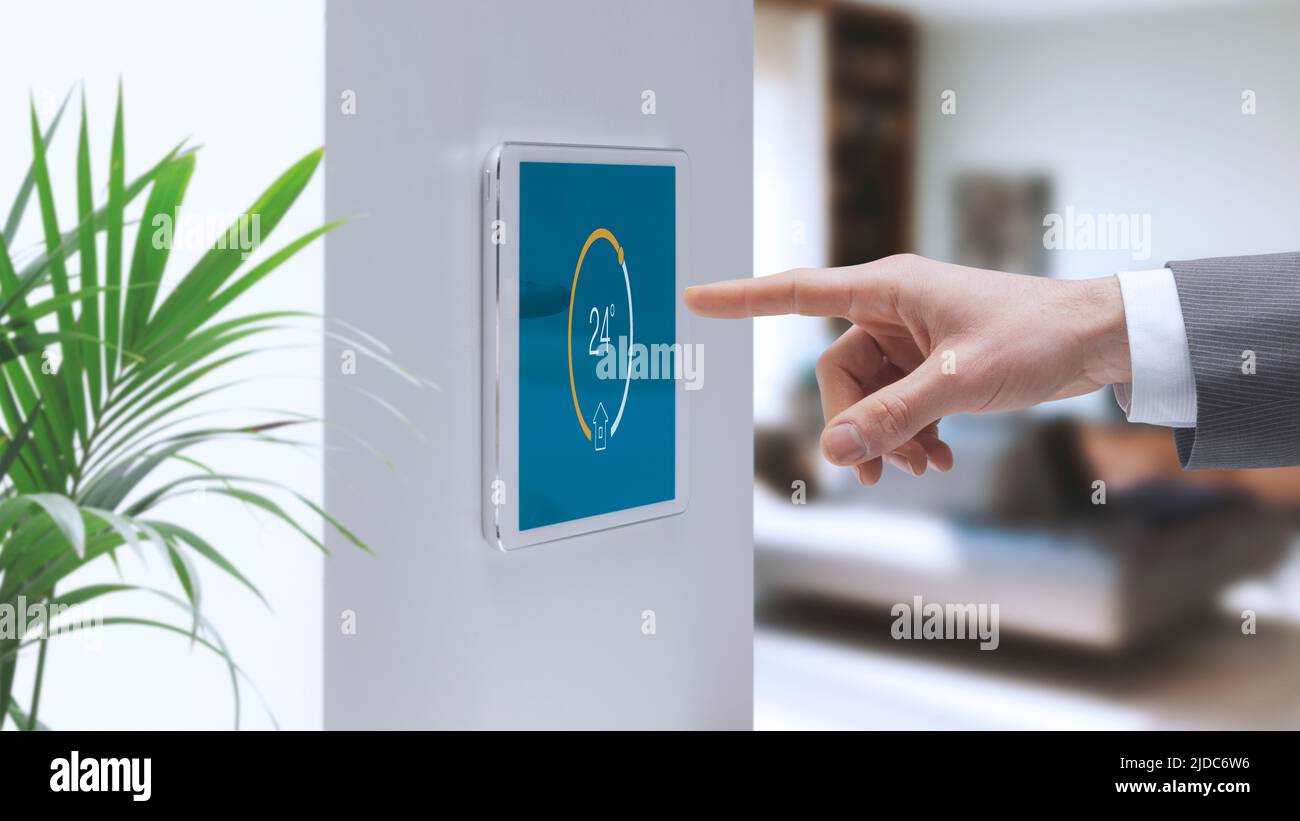 Man setting home interior temperature on the smart home system control panel, home automation concept Stock Photo
