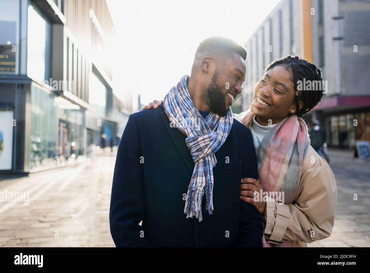 Cheerful couple wearing scraves out and about in the city centre Stock Photo