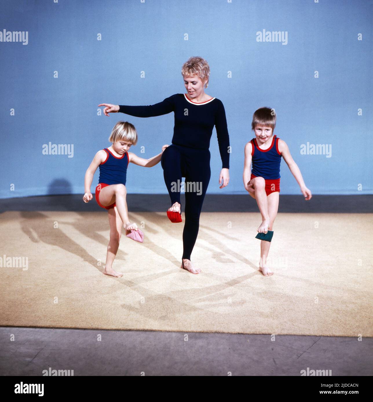 Turn mit!, Gymnastik Serie, Deutschland 1972, Vorturnerin Bärbel Vitt mit den Kindern Kathrin und Jan-Christoph arbeiten mit Bohnensäckchen Stock Photo