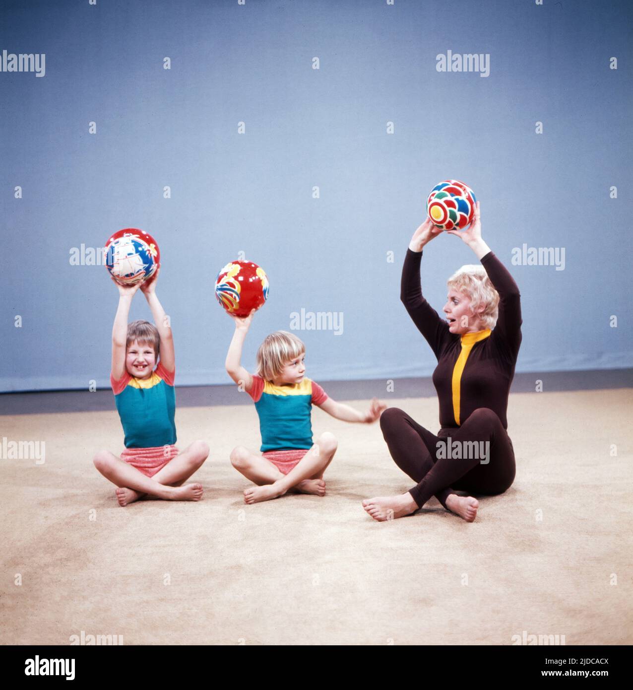 Turn mit!, Gymnastik Serie, Deutschland 1972, Vorturnerin Bärbel Vitt mit den Kindern Kathrin und Jan-Christoph bei einer Übung mit dem Ball Stock Photo