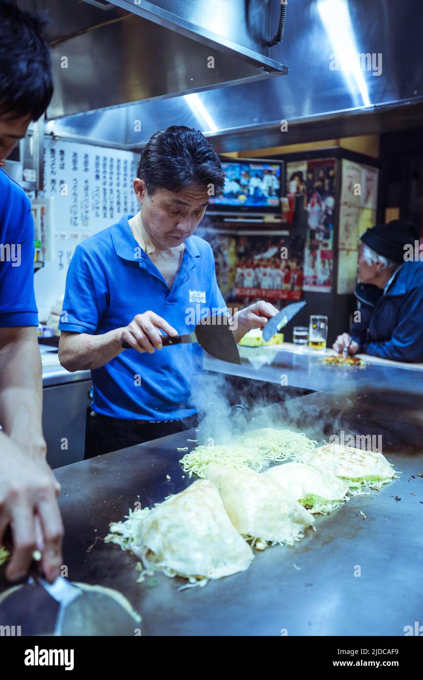 Local Cook preparing the Typical Japanese Dish Okonomiyaki in Hiroshima