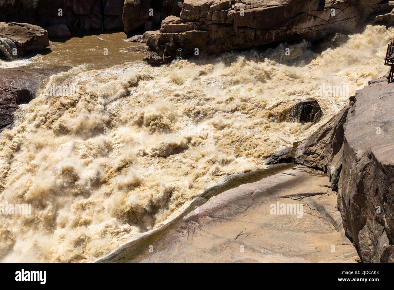 Brown flood water at Augrabies falls in the Oranje river in South Africa. Stock Photo