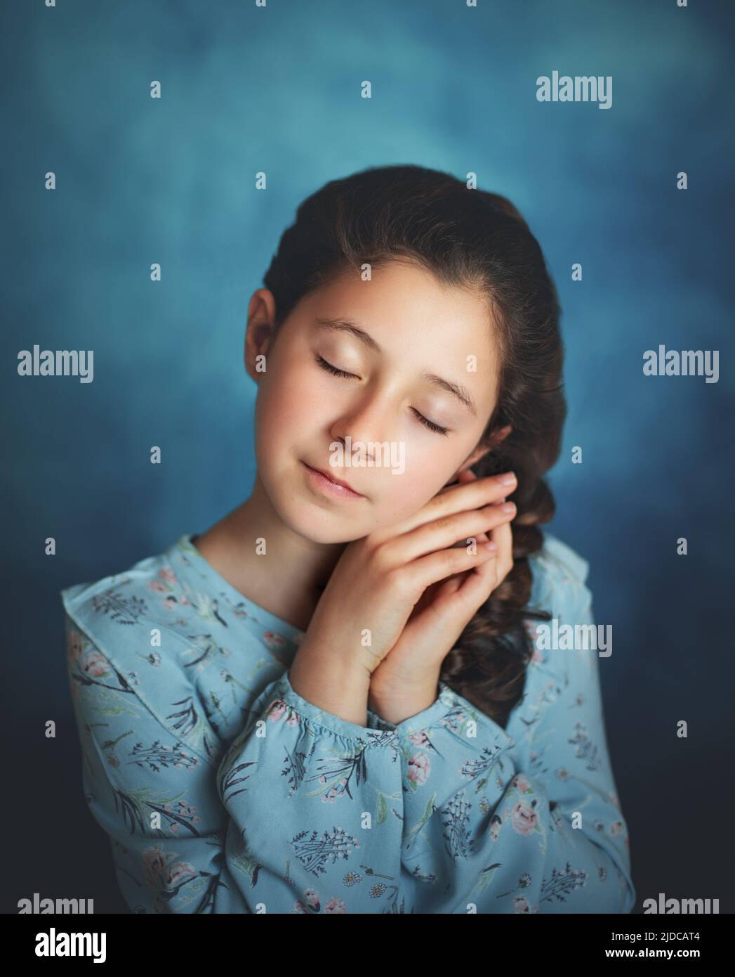 Portrait of a girl with her eyes closed on a blue background Stock ...
