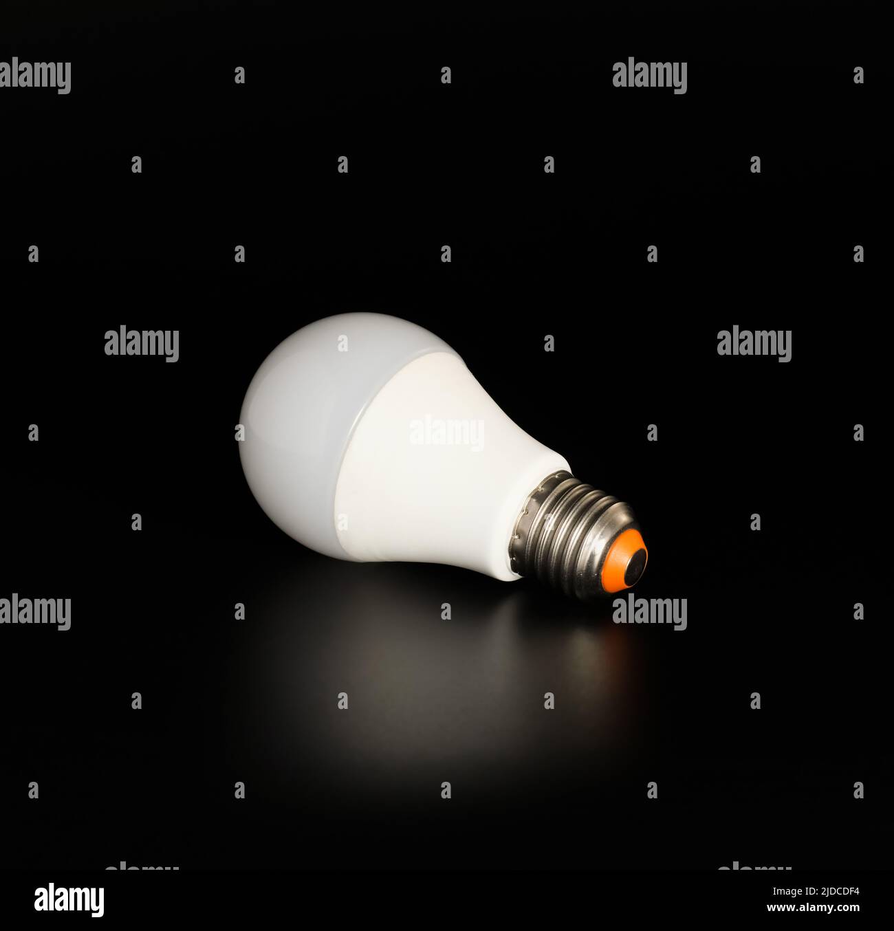 Economical LED light bulb with reflection on a black background Stock Photo