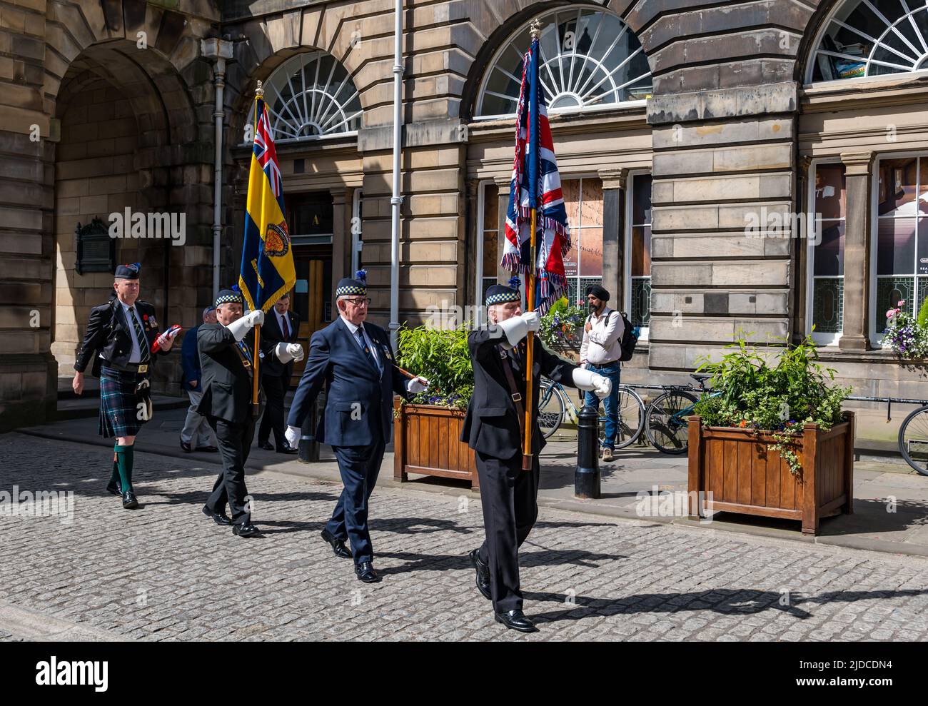 City Chambers, Edinburgh, Scotland, United Kingdom, 20 June 2022. Armed Forces flag raising ceremony: A procession with Armed Forces Day flag at City Chambers with a Parade Marshall, standard bearers & Eddie Maley carrying the flag plus guests Lt Cdr Will McLeman (Royal Navy) Garrison Commander Lt Col Lorne Campbell (British Army) & Squadron Leader Derek Read (Royal Air Force). The Flag Raising Ceremony is a national event to honour Armed Forces personnel Stock Photo