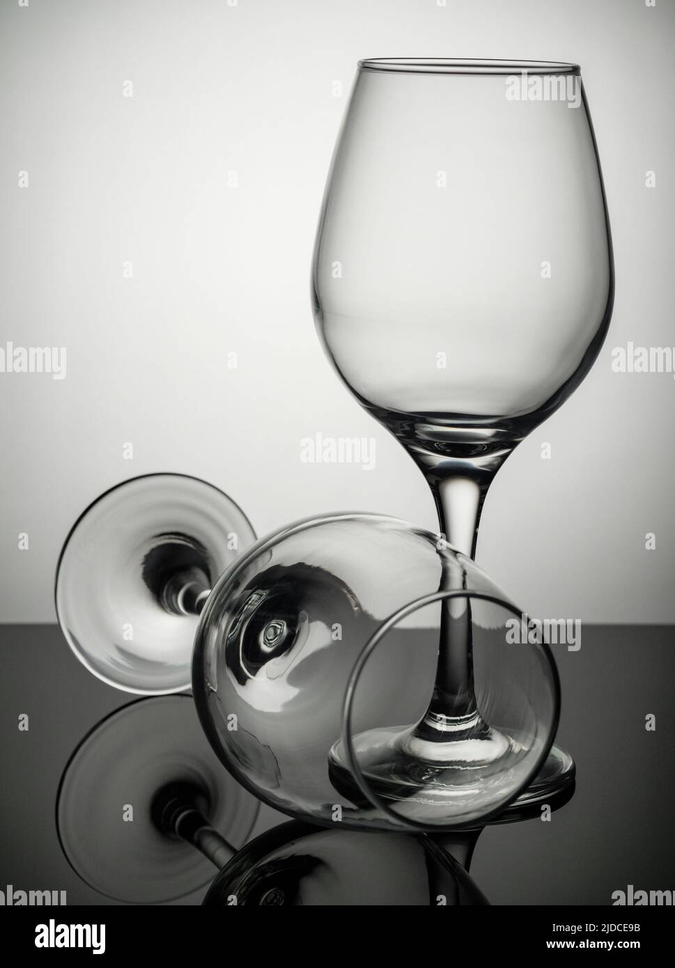 Two wine glasses standing on a grey surface Stock Photo