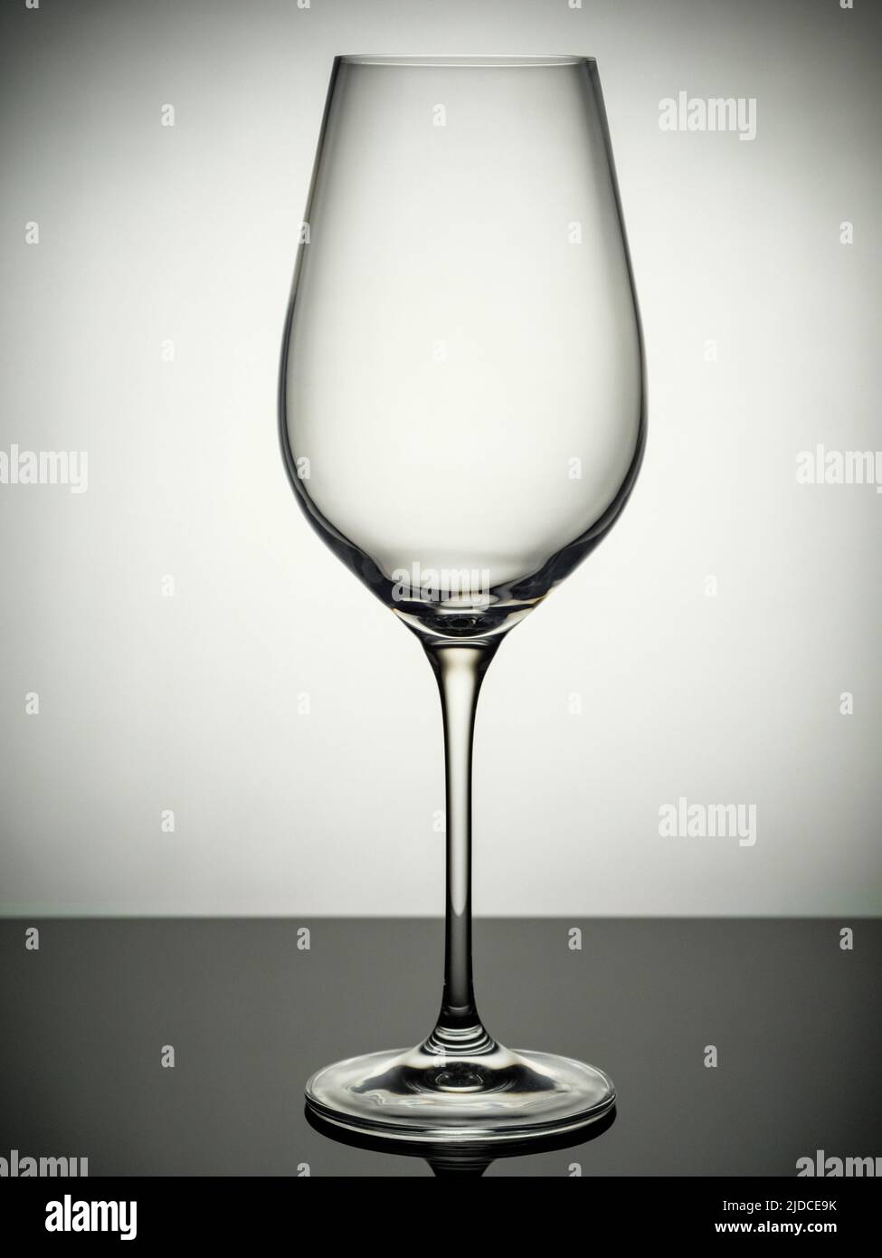An empty champagne glass stands on a gray table Stock Photo