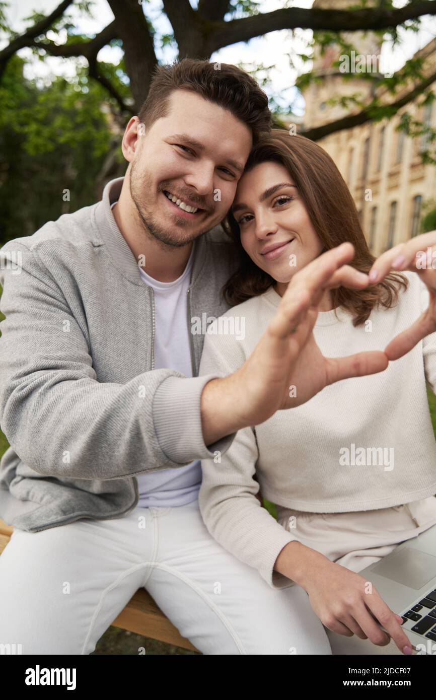 Happy couple making heart symbol with hands on the street Stock Photo ...