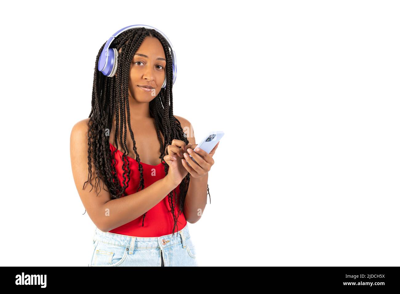 Young black woman listening to music with her phone on a white background Stock Photo