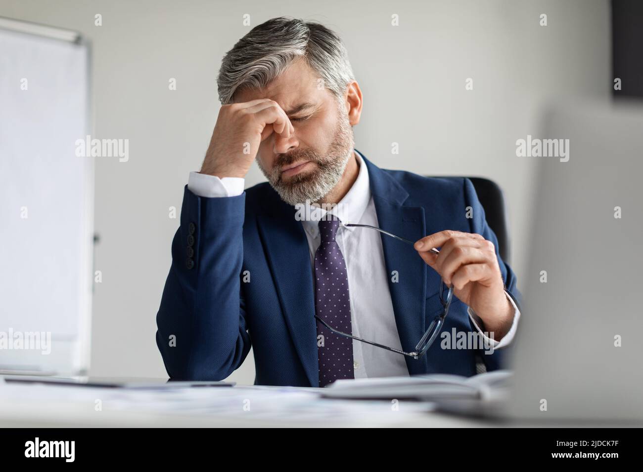 Stressed Middle Aged Businessman Suffering From Headache At Work, Stock Photo