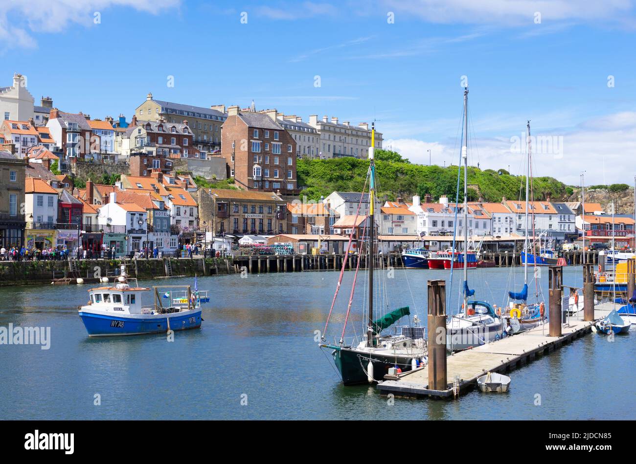 Whitby Yorkshire Whitby Harbour with small fishing boat coming into the harbour and the quayside Whitby North Yorkshire England UK GB Europe Stock Photo