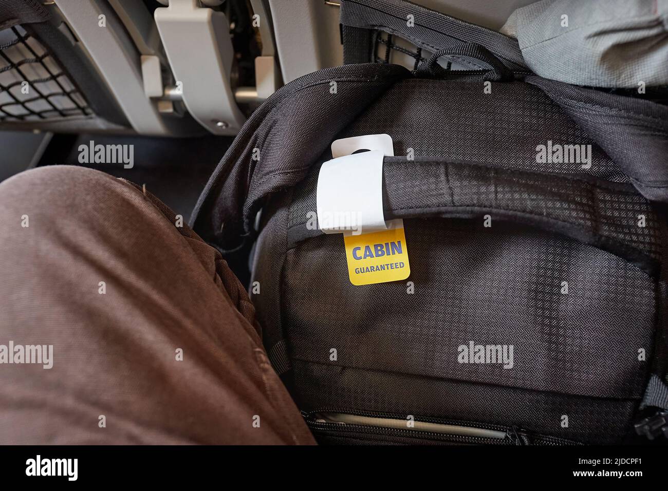 Cabin bag in front of seet on economy class flight Stock Photo