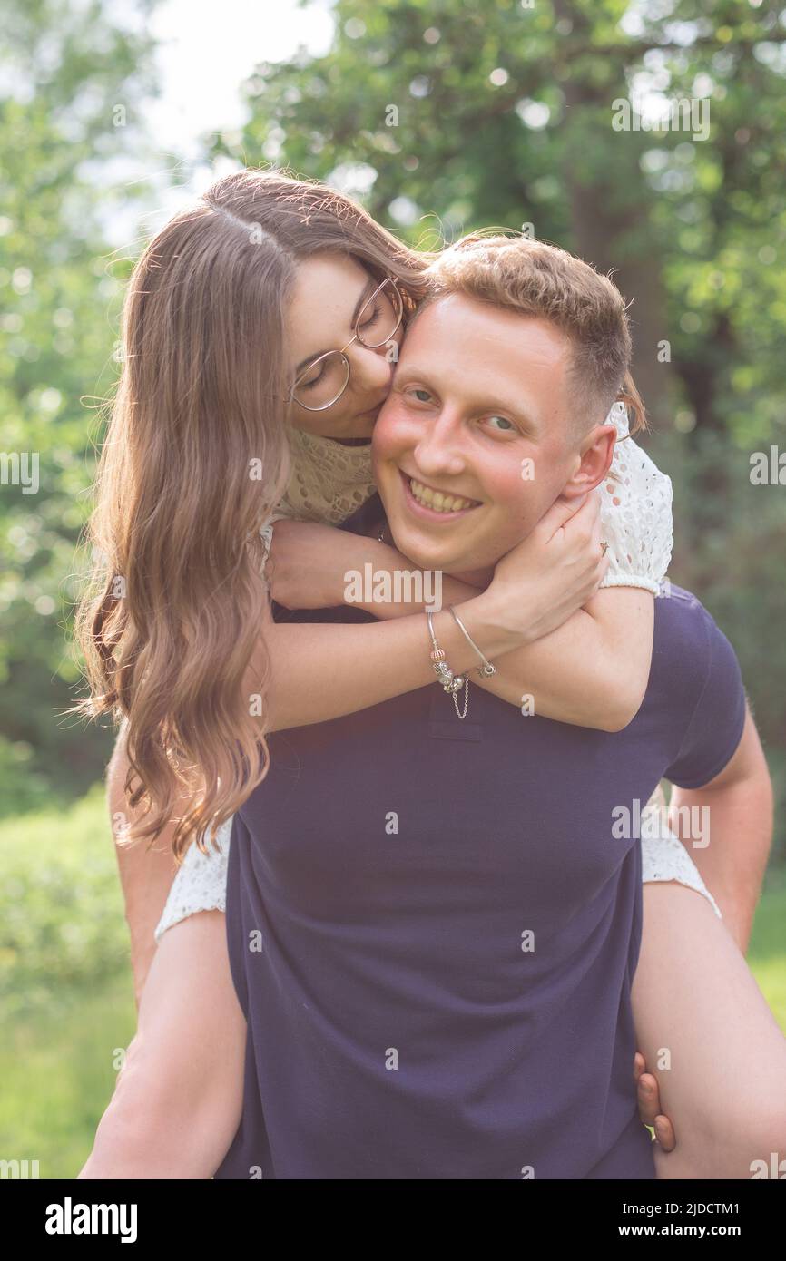 Summer happiness, friendship, stroll, holiday concept. awesome man piggybacking his woman Stock Photo