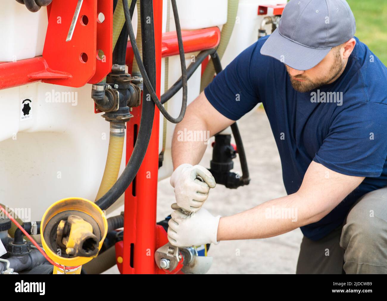 The farmer repairs agricultural machines in field Stock Photo