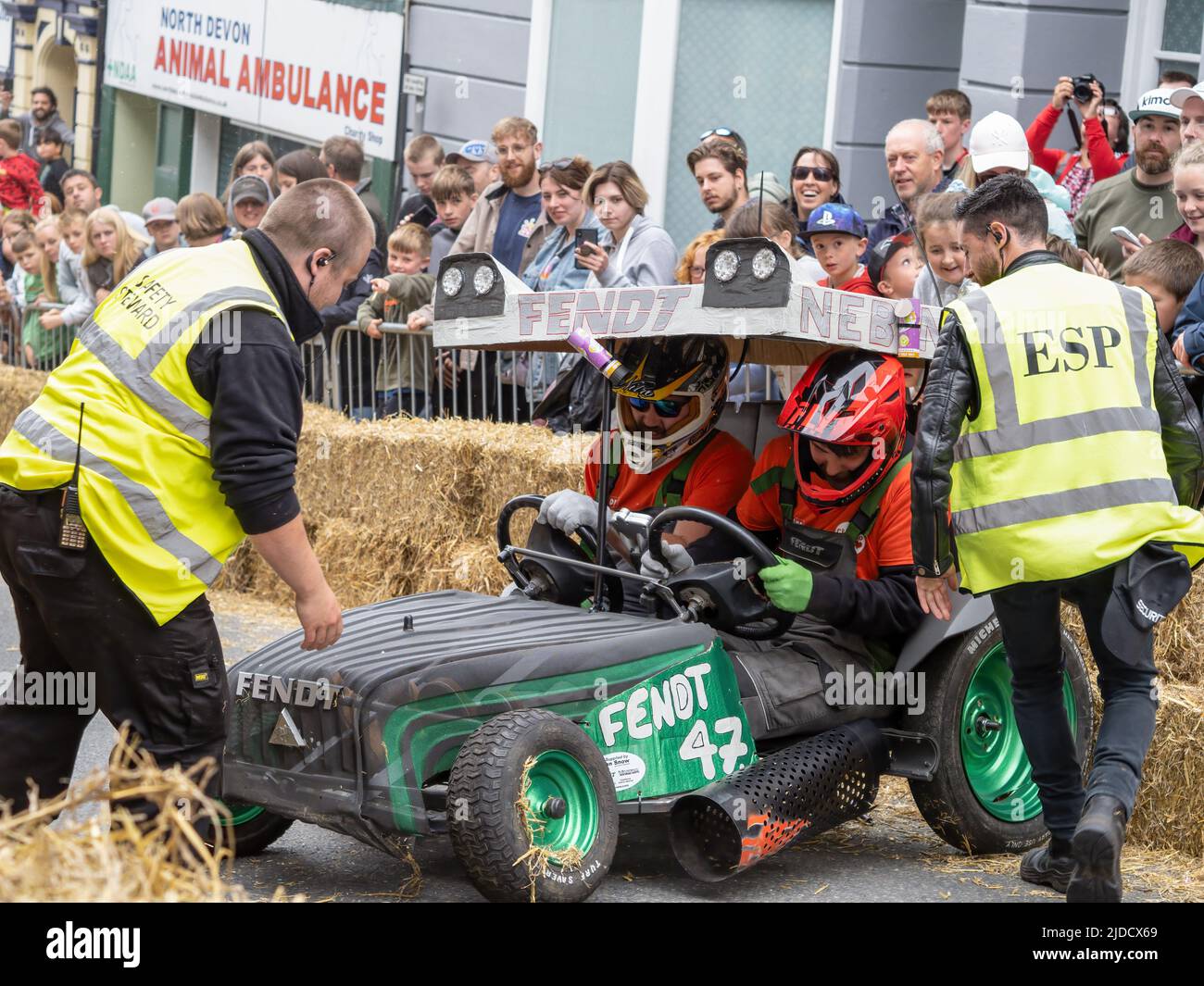 BIDEFORD, NORTH DEVON, ENGLAND - JUNE 19 2022: Participants in the annual Soap Box Derby, fundraising for charity Chemohero. Fendt cart in difficulty. Stock Photo