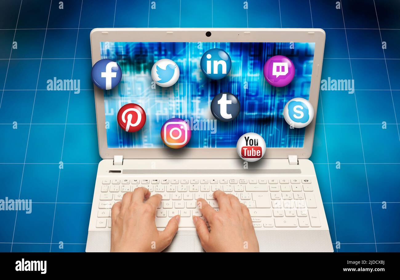 hands on laptop with icons of logo of social media services Stock Photo