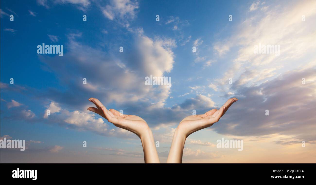 Hands on blue sky clouds background. Power of hope or love and devotion Stock Photo