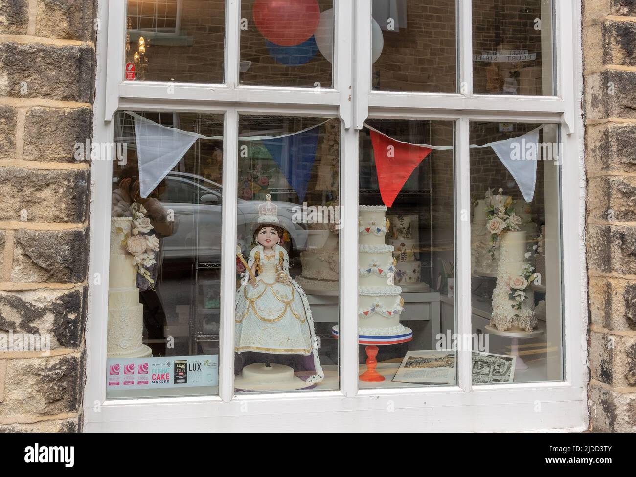 Village cake shop widow display with Queen Jubilee cakes decoration in Saddleworth, England. Stock Photo