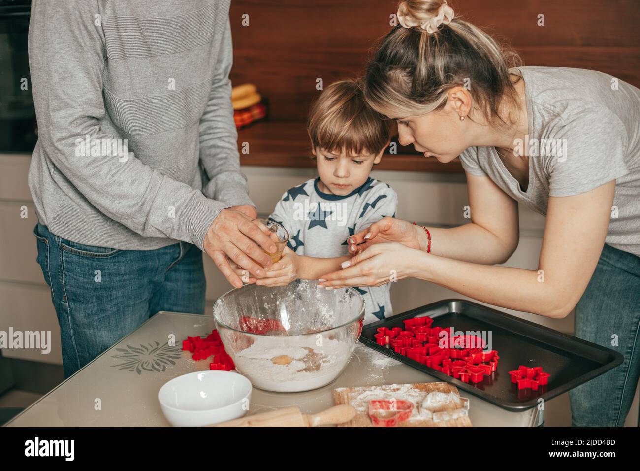 Baking process of young family, people have fun in kitchen at home. Father, mother and child cooking together, little boy 4-5 years old, Stock Photo