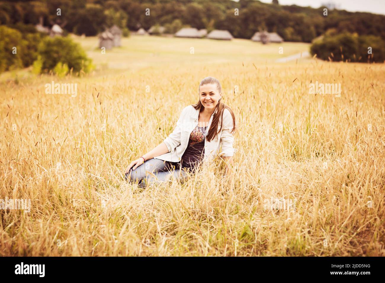 Portrait of a confident authentic woman sitting in a field in the countryside Stock Photo