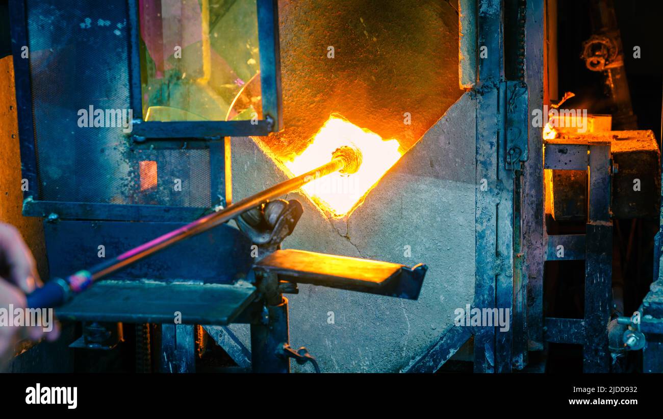 Softening glass in a kiln during glassblowing process Stock Photo