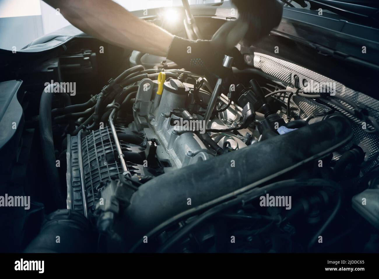 Serviceman changes spark plugs in modern turbocharged engine. Timely