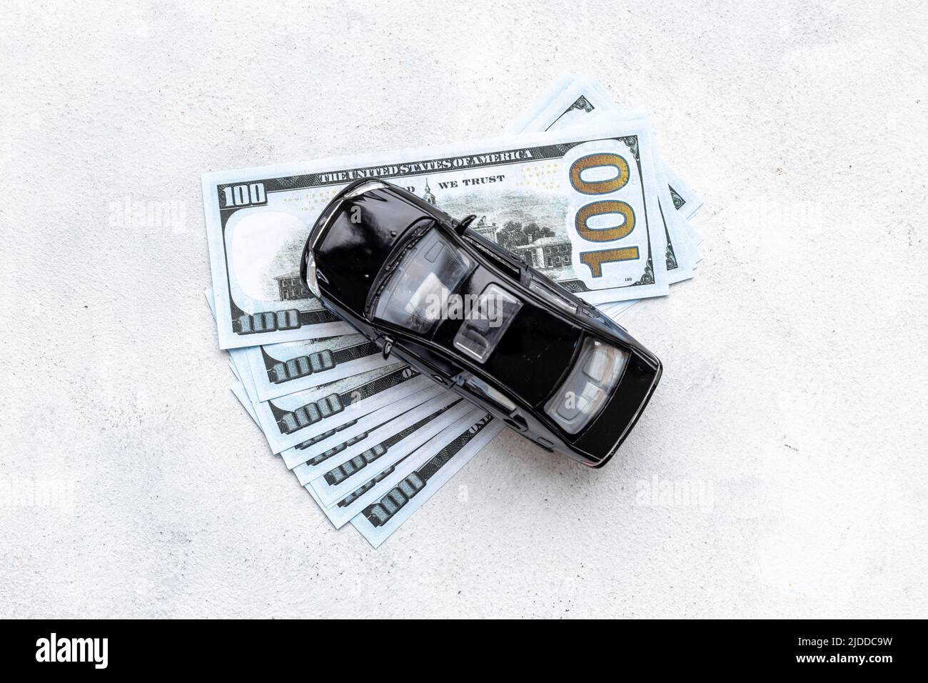 Money to buy or rent a car concept. Toy car with money cash Stock Photo