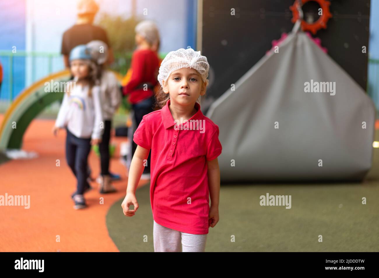 Cute little girl climber dressed protective hat before dress up helmet