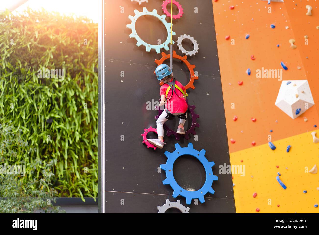 Child climbing on wall in amusement centre. Climbing training for