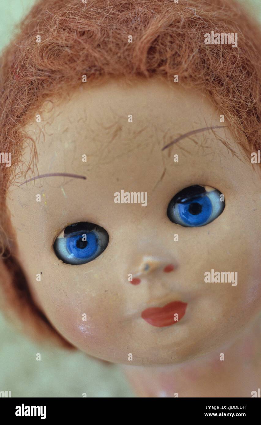 Close up of 1960s doll head with piercing blue eyes and frizzy red hair Stock Photo