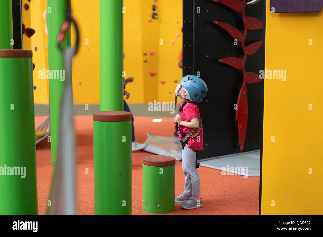 Child climbing on wall in amusement centre. Climbing training for
