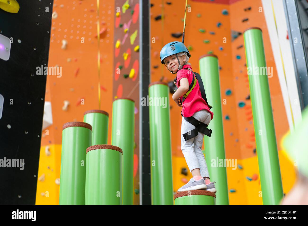 Child climbing on wall in amusement centre. Climbing training for