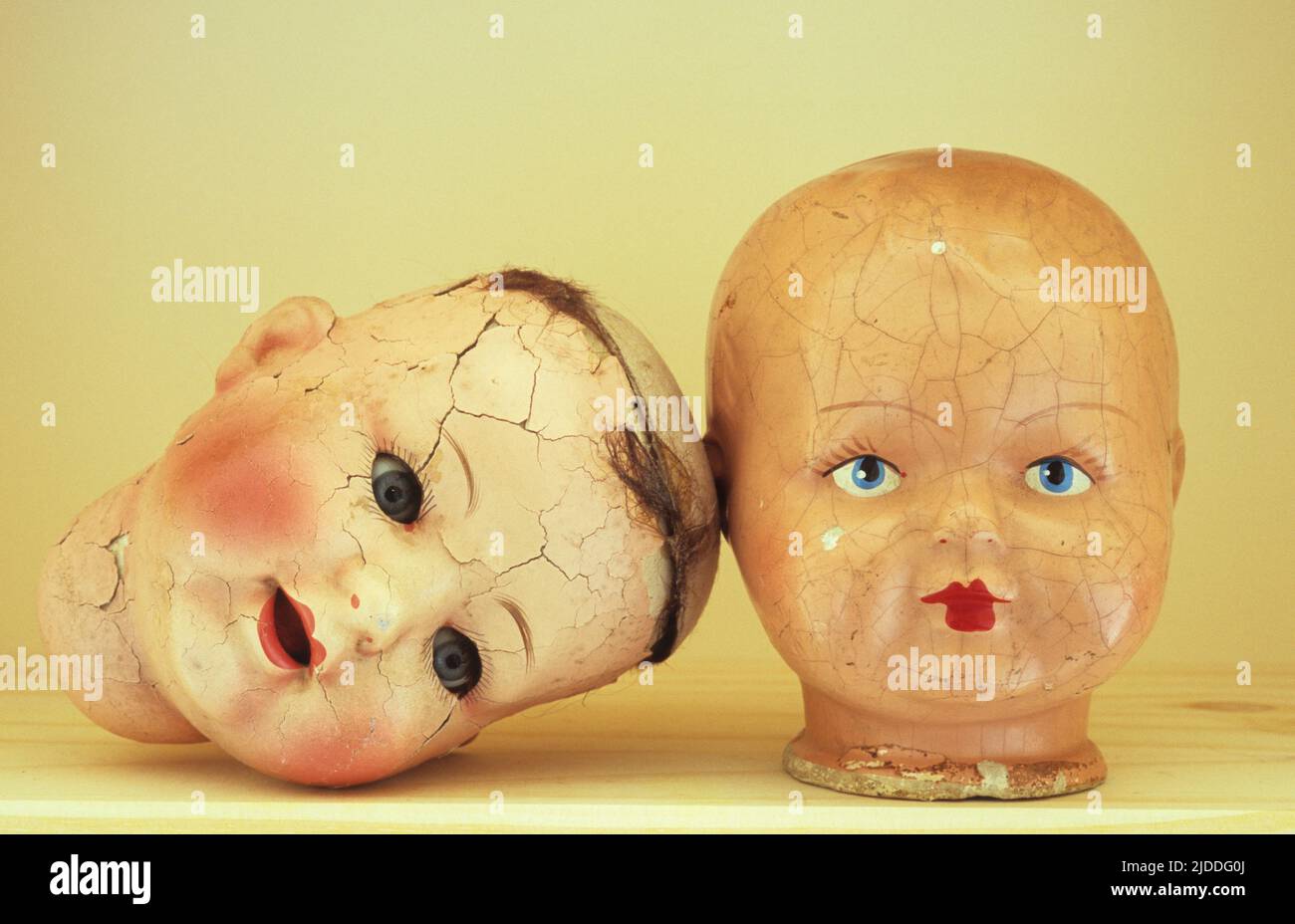 Two cracked doll heads Stock Photo - Alamy