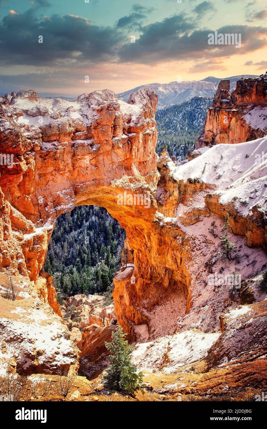 A thin layer of snow covers the ground in early winter at Natural Bridge in Bryce Canyon National Park, Utah. Stock Photo