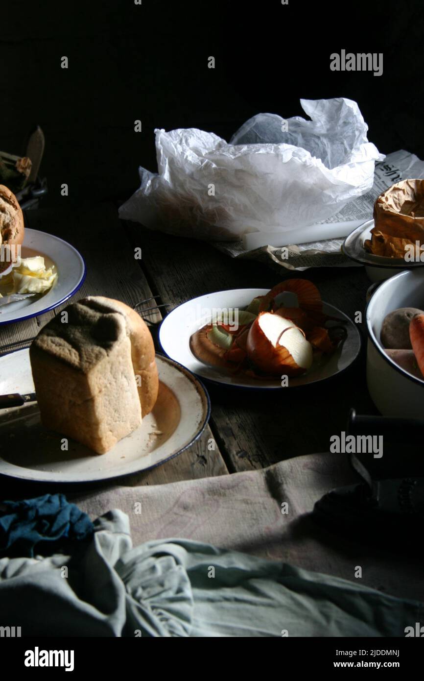 Traditional English Ploughman's Lunch. A still life view of a simple and traditional ploughman's lunch set on a rustic kitchen table. Stock Photo