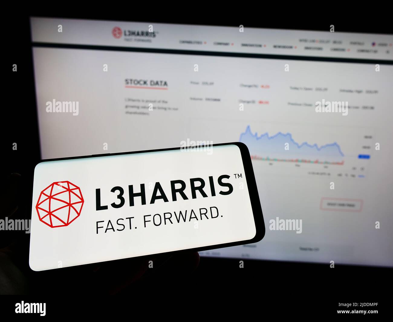 Person holding mobile phone with logo of US aerospace company L3Harris ...