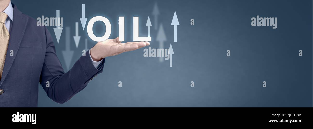 Oil trend. Energy crisis with stock market. current change in price of barrel of oil. usinessman showing word oil and arrow up and down. wide blue ban Stock Photo