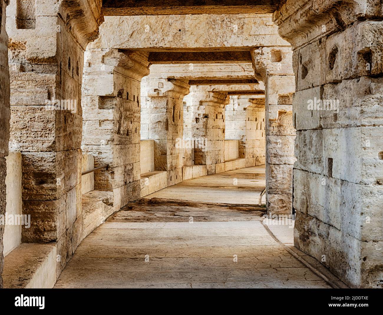 A broad concourse with stone pillars circles the old Roman ampitheatre in Arles. Stock Photo