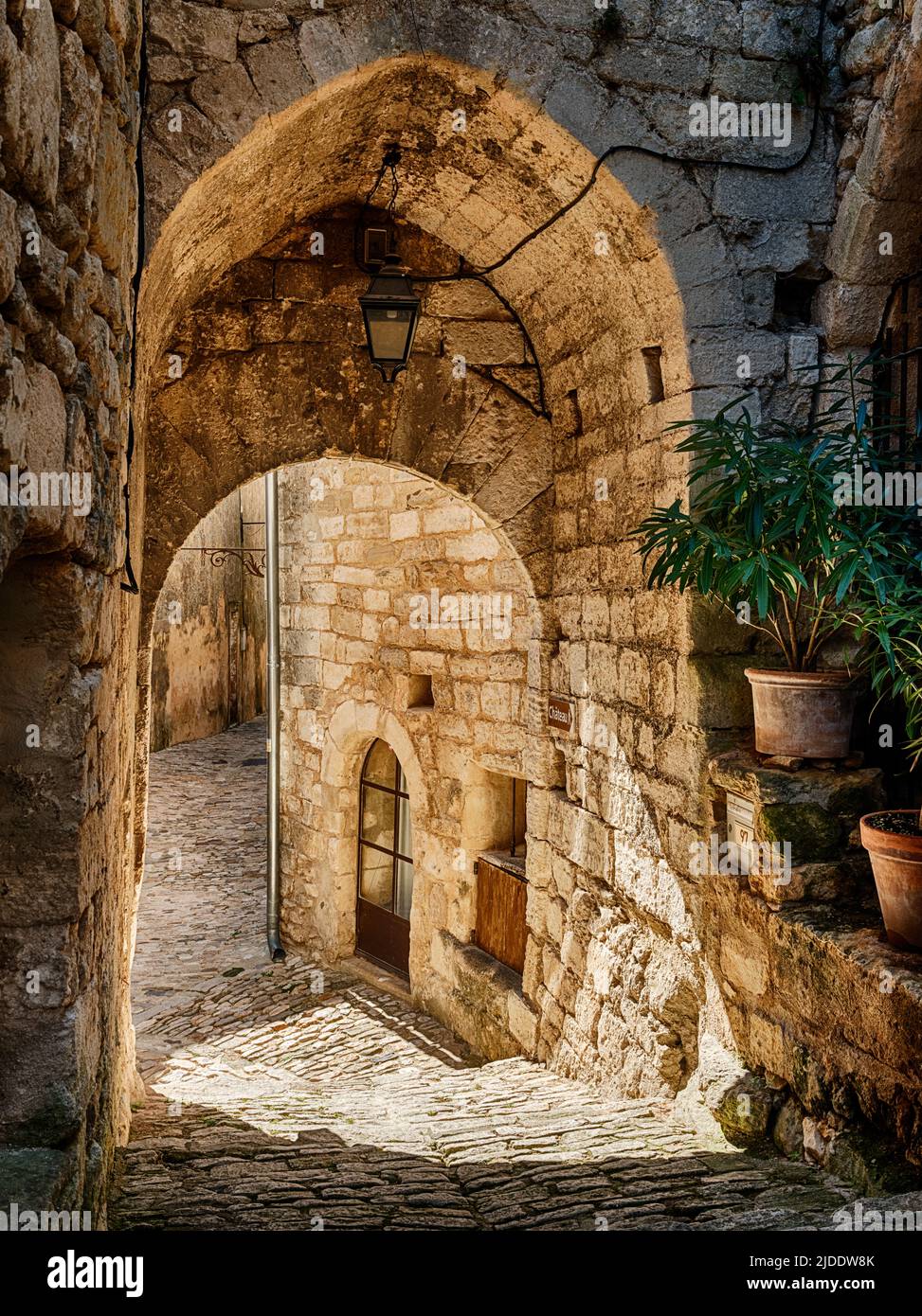 A stone arch in Lacoste frames one of the narrow streets in this Luberon hilltown. Stock Photo