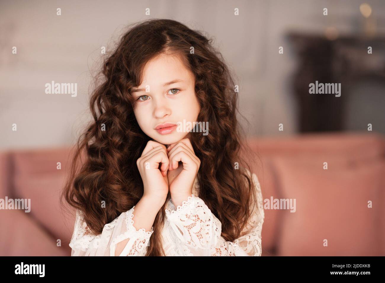 Cute beautiful kid girl 10-12 year old with long dark blonde hair in room close up. Portrait of young teenager. Childhood. Stock Photo